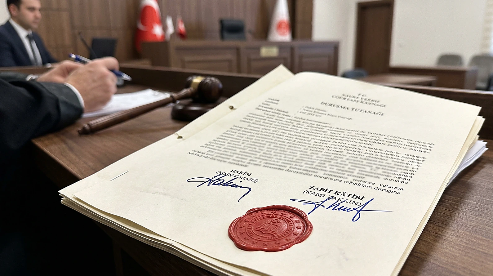 Resmi mühürlü ve ıslak imzalı duruşma tutanağının yakın çekimi.